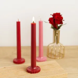 Detailed view of red and pink geometric pillar candles with decorative gear bases