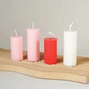 Set of colorful pillar candles in various heights on a wavy wooden display tray