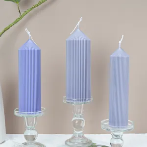 Set of three purple ribbed cathedral pillar candles on glass stands for home decor