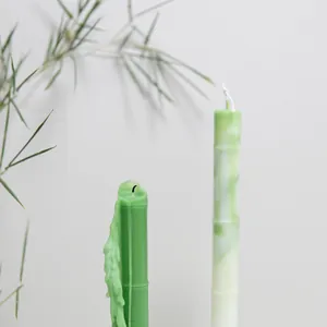 Close-up detail showing the texture of bamboo-shaped green candles in a minimalist setting