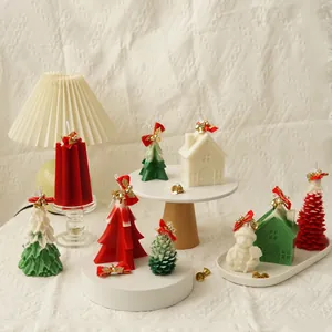 Festive collection of Christmas tree and house shaped candles with gold bells and bows