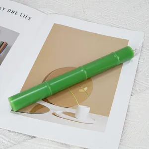 Detail of a green bamboo-shaped candle with realistic bamboo joint design.