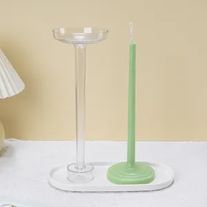 Comparison of a tall transparent acrylic candle mold with a finished green tapered candle