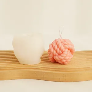 Yarn ball silicone mold shown next to a finished pink textured rope knot candle