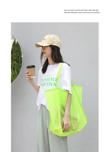 Vista detallada de un moderno bolso de malla verde neón llevado por una modelo