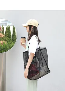 Mujer con un bolso de malla negro para ir de compras en un entorno exterior urbano