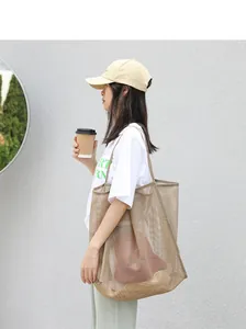 Elegante bolso shopper de malla beige mostrado en una modelo para un look muy casual