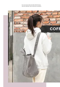 Lifestyle view of a casual grey vintage washed canvas shoulder bag worn by a model.