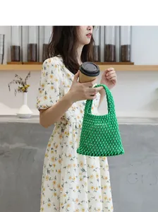 Detailansicht einer handgefertigten grünen Netztasche aus Baumwolle, von Modell gehalten