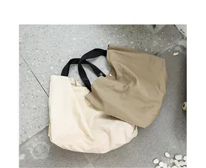 Vista dettagliata di due grandi borse tote in nylon impermeabile in beige e kaki
