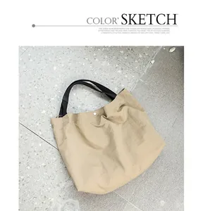 Vista dettagliata di una borsa tote beige minimalista su un pavimento grigio piastrella