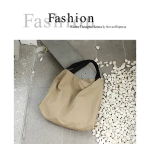 Vista dettagliata della borsa tote in nylon impermeabile kaki in un ambiente esterno casual