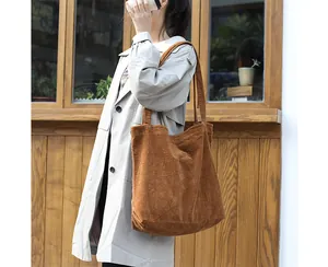Close-up showing the rich texture of a vintage brown corduroy tote bag on a model's shoulder