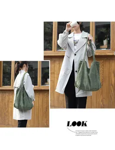 Model wearing a large green corduroy tote bag in a casual street style look.