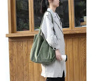 Stylish large green corduroy tote bag shown in a casual outdoor lifestyle setting