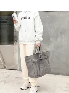 Professional lifestyle detail of a large grey washed canvas tote bag with model