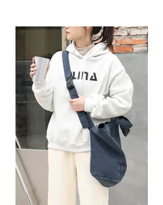 Lifestyle detail of a person wearing a navy washed canvas crossbody bag outdoors