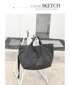 Casual black washed canvas tote bag shown on a minimalist display rack outdoors