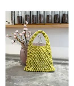 Nahaufnahme der aufwendigen Textur der handgewebten grünen Baumwoll-Gitterhandtasche.