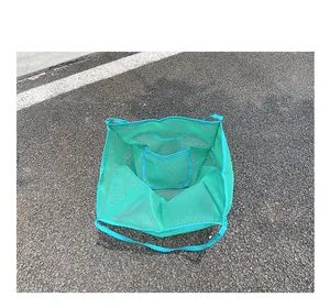 Detalle de un bolso de malla verde que muestra el amplio compartimento interior abierto.