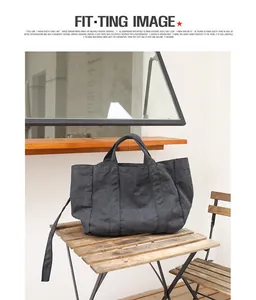 Detailed view of a dark washed canvas tote bag resting on a rustic wooden table