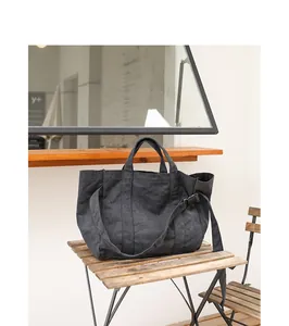 Minimalist dark grey large capacity washed canvas shoulder bag on a wooden table