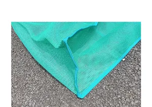 Detalle de primer plano de bolsa de malla verde que muestra material y costuras.