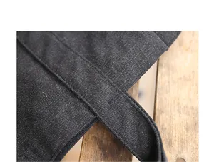 Close-up detail of a black washed canvas bag strap showing durable stitching and texture