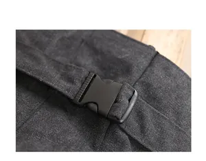 Close-up detail of a black plastic buckle on a washed canvas shoulder bag fabric texture