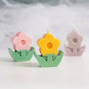 Detailed macro view of colorful flower-shaped aromatherapy candles on green bases