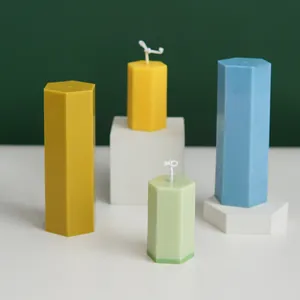 Detailed view of colorful hexagonal pillar candles in various sizes on white display blocks