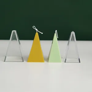 Close-up detail of clear pyramid candle molds with yellow and green finished wax samples