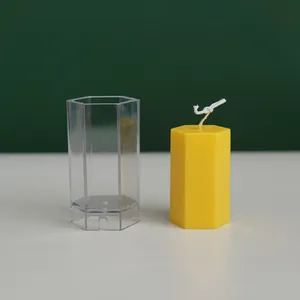 Close-up detail of a transparent hexagonal candle mold and a finished yellow candle.