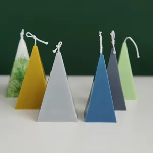 Detailed view of handmade pyramid-sided scented candles in various modern aesthetic colors