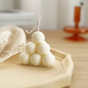 Primo piano dettagliato di una candela a bolle bianca su un vassoio decorativo con texture