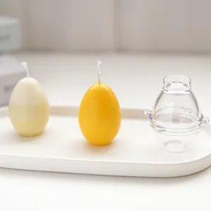Transparent egg-shaped candle mold shown with finished yellow and white wax eggs.