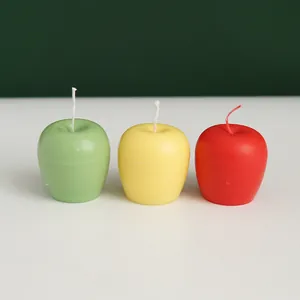Set of three realistic apple shaped fruit candles in red, yellow and green colors
