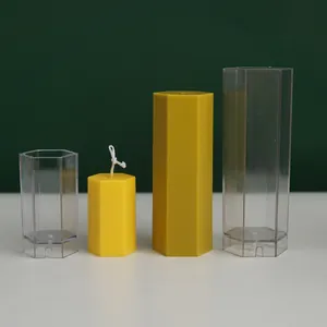 Transparent hexagonal column candle molds shown with finished yellow wax candles for DIY