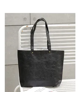 Detail view of the black DuPont paper tote bag showing its unique wrinkled texture