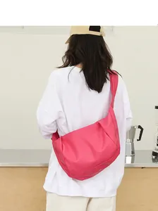 Detalle de un bolso bandolera de cuero PU rosa plisado llevado por una modelo con estilo casual