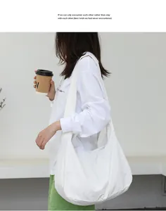 Lifestyle detail of a white minimalist nylon hobo shoulder bag worn by a model