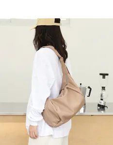 Vista trasera de un bolso tipo dumpling de cuero PU suave beige con detalles de pliegues