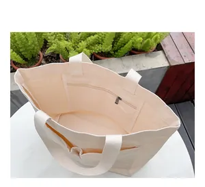 Innenansicht einer großen cremefarbenen Segeltuchtasche mit Reißverschlussfach.