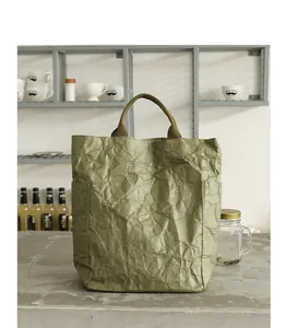 Lifestyle view of a vintage olive green DuPont paper tote bag with wrinkled texture