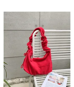 Close-up of a vibrant red corduroy hobo bag with a stylish ruched shoulder strap.