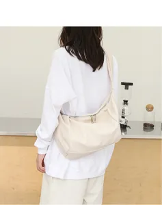 Vista detallada del bolso de hombro suave de cuero PU beige llevado por una modelo en estilo casual