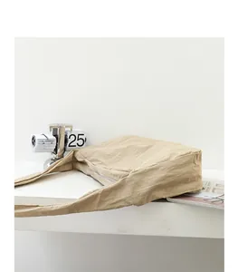 Detailed view of a minimalist beige nylon shoulder bag showing its soft crinkled fabric texture