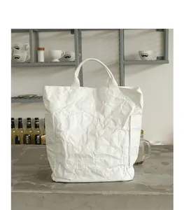 Detail of white DuPont paper tote bag with unique wrinkled texture and minimalist design