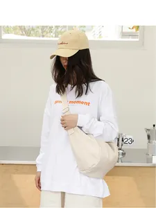 Modelo con un bolso bandolera de cuero PU crema en un entorno interior minimalista