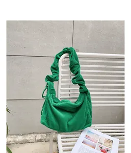Detailed view of the vibrant green corduroy fabric on a stylish hobo shoulder bag.